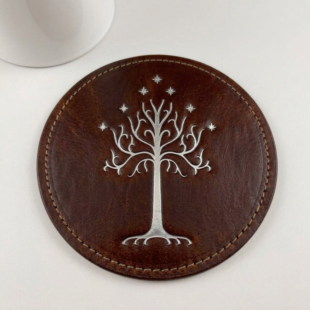 Close-up of a round brown cowhide leather coaster with silver White Tree embossing