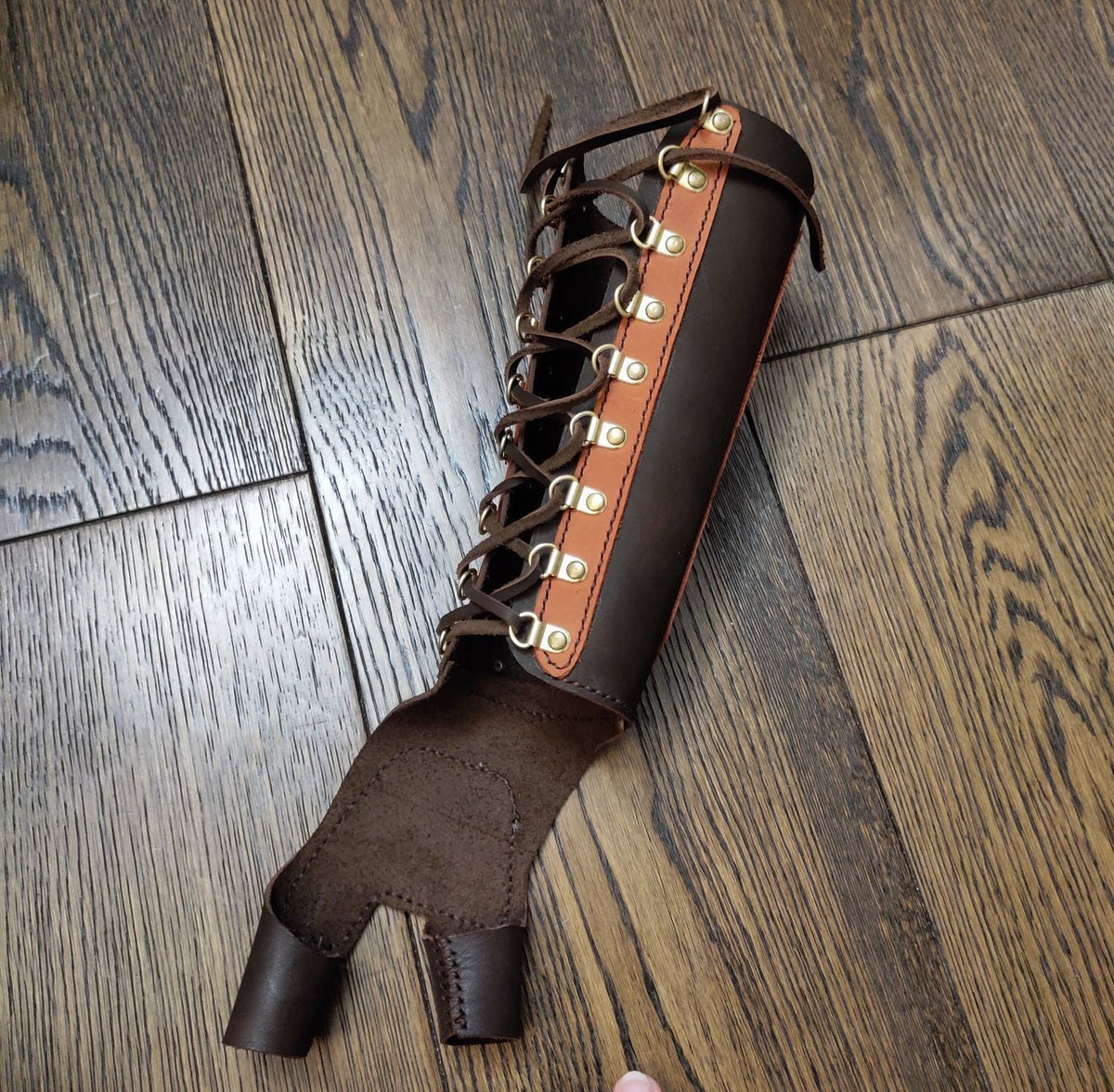 Close view of the lacing and integrated hand guard on the archery bracer