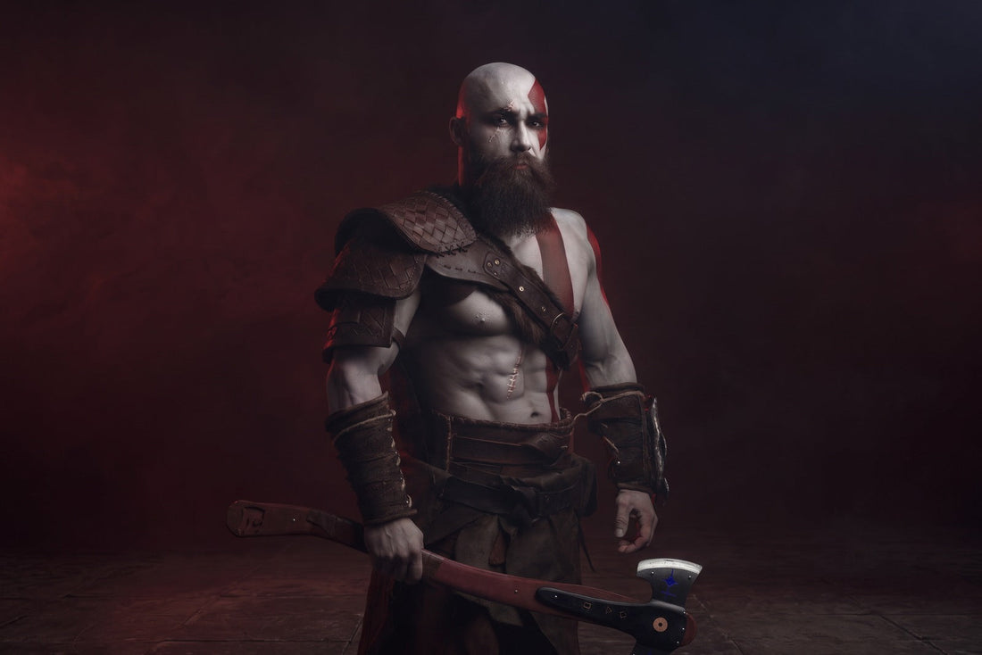 Kratos-inspired costume with brown shoulder armor, crossed torso strap, bracers, waist armor, and an axe against a dark red studio background