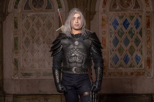 Man wearing black Witcher-inspired leather cuirass, layered pauldrons, bracers, and a silver medallion