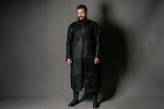 Model wearing a long black leather Aragorn Strider duster with front ties and stitched panels