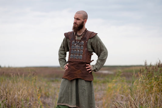 LARP player wearing brown leather armor over a green tunic outdoors