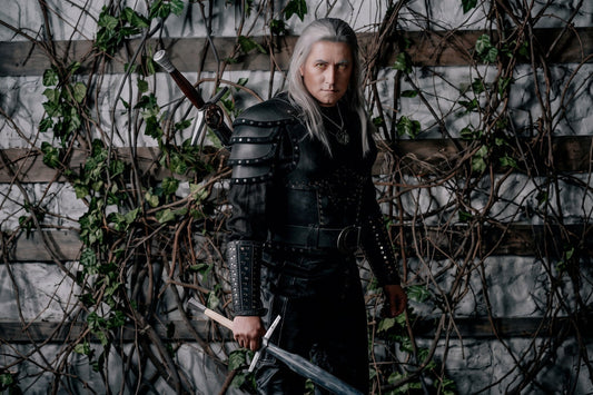 Three-quarter view of the Geralt Season 2 costume showing layered shoulder armor, cuirass side fit, bracer, belt, and pants