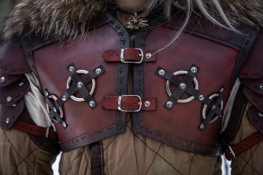 Close view of brown leather Bear School armor with stitched panels, metal rings, buckles, and fur-trimmed collar