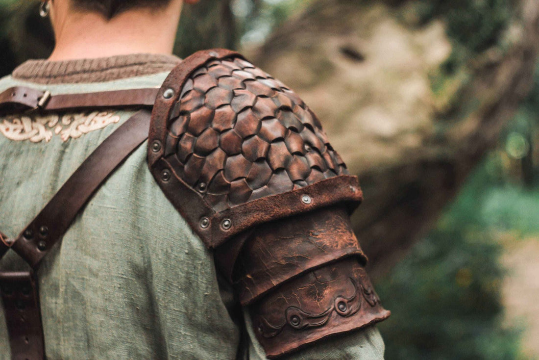 Brown segmented leather shoulder armor worn over a green tunic outdoors