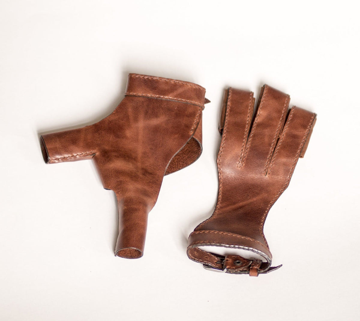 Two views showing the three-finger shape and wrist fastening of the archery glove