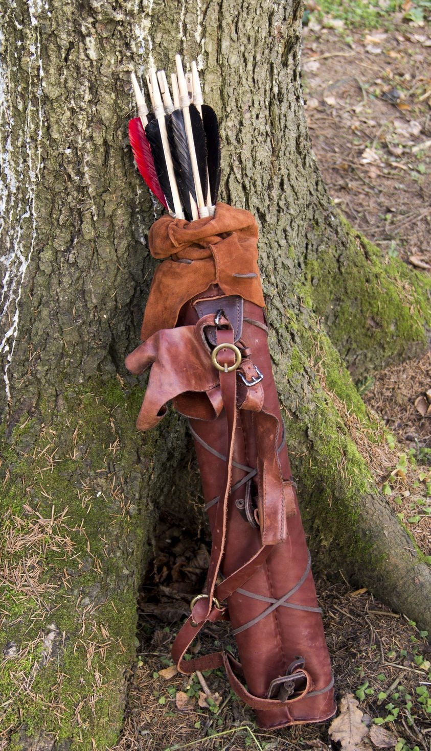 Brown leather ranger back quiver with protective cover and arrows beside a tree