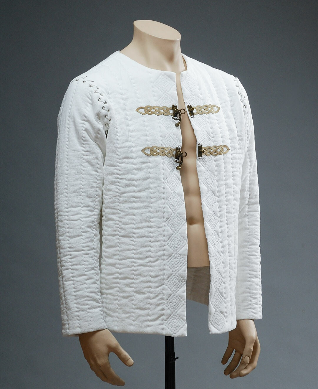 Ivory quilted medieval jacket with leather ornament, angled view