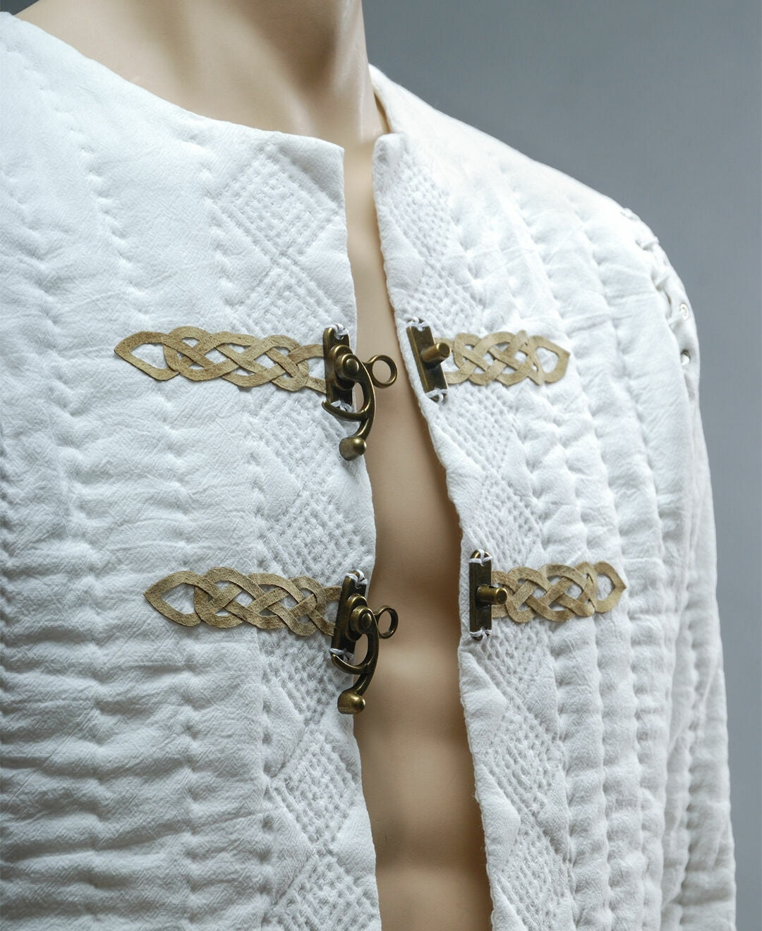 Close-up of leather ornament and metal closures on quilted jacket