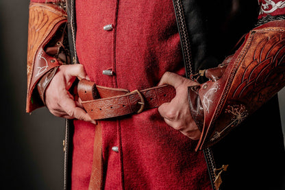 a person holding a pair of scissors in a red shirt 