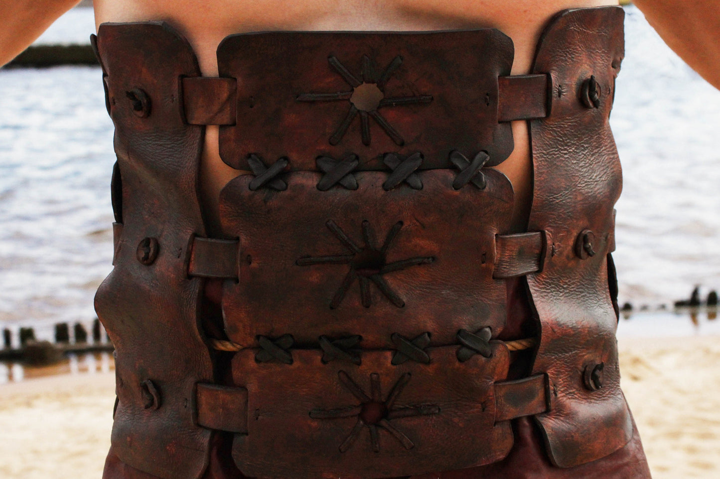 a close up of a wooden vase on a beach 