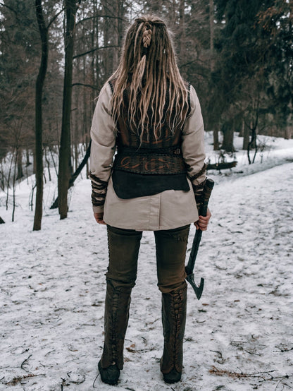 a woman standing in the snow holding a pair of skis 