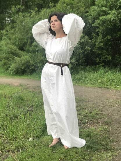 a woman in a white dress holding a frisbee 