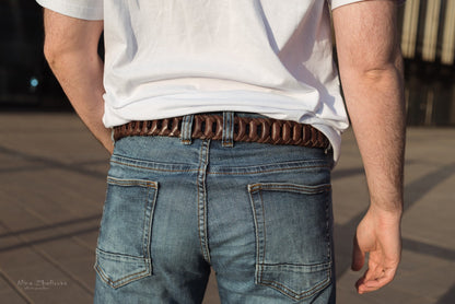 a person standing on a sidewalk holding a skateboard 