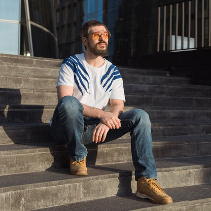 a man sitting on a bench in a park 