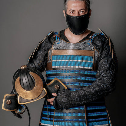 a man wearing a hat and holding a tea pot 